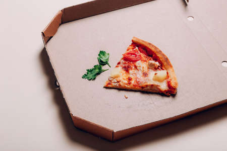 One pizza piece in delivery box, close upの写真素材