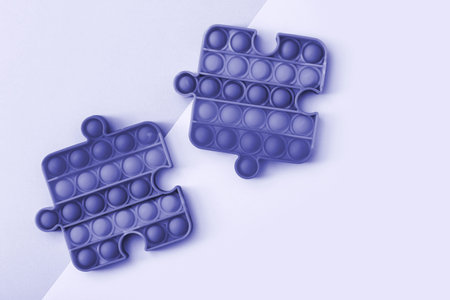 Popit toy in the form of a puzzles toned in blue color. Multicolored Pop it toyの写真素材