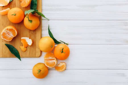 Fresh clementines with leaves on white wooden table.の写真素材