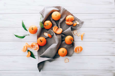 Fresh clementines with grey napkin on white wooden table background, top viewの写真素材