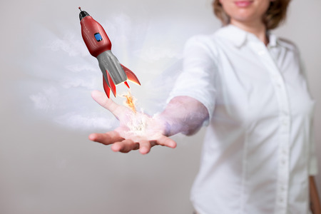 Womans hand with red flying rocket. の写真素材