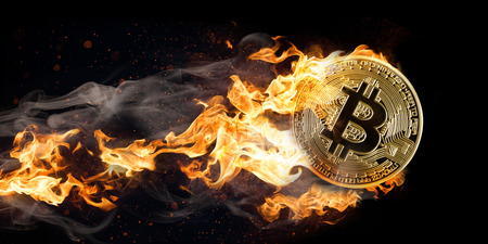 Flying burning bitcoin on the black background.の写真素材