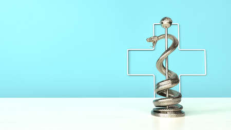 An aesculapian staff on the white table. 3d illustration.の写真素材