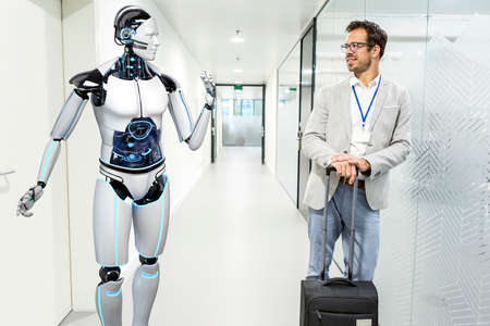 Humanoid robot talks with the businessman in the company hallway.の写真素材