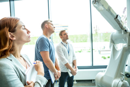 Engineers inspect industrial robot in a hall.の写真素材