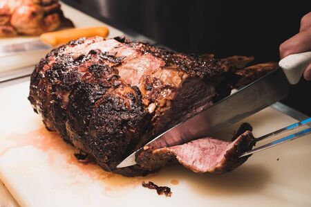 Chef is slicing a big chunk of beef  on a white cutting boardの写真素材