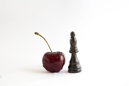 cherry stand on white background with black chessの写真素材