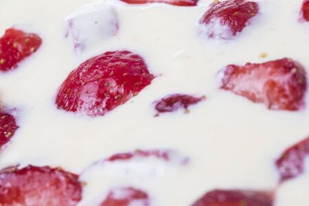 filled frame background wallpaper shot of strawberries on the surface of a milky white vanilla cheese cake cream liquidの写真素材