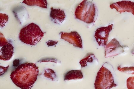 filled frame background wallpaper shot of strawberries on the surface of a milky white vanilla cheese cake cream liquidの写真素材