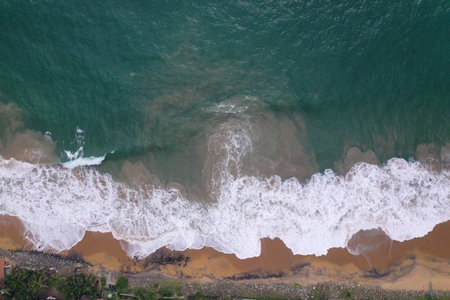 defaultaerial drone bird view shot of the sea shore with turquoise blue water, large white waves and...