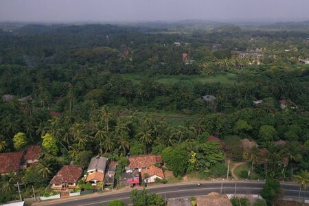 natural aerial drone bird view day shot of the sea shore with a road, beautiful villas and green forest trees. Pitiwella, Sri Lankaの写真素材