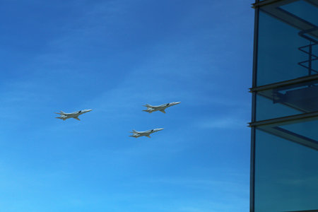 a triangular formation of a group of three russian military fighter jet planes flying high in blue...