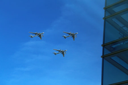 a triangular formation of a group of three russian military fighter jet planes flying high in blue...