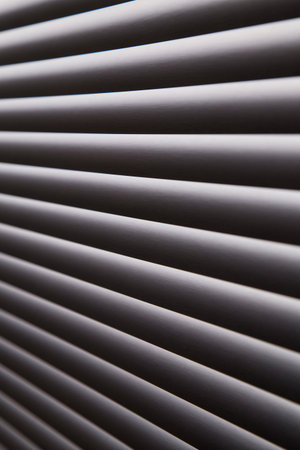 contrasty abstract close up filled frame background wallpaper shot of grey window blinds with rays...