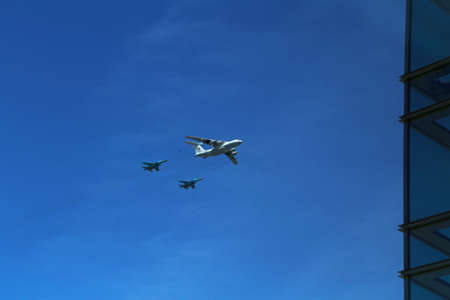 a triangular formation of a group of three russian military fighter bomber jet planes flying high in blue sky during Vicotry Day parade air show on 9 May in Moscow, Russiaのeditorial素材