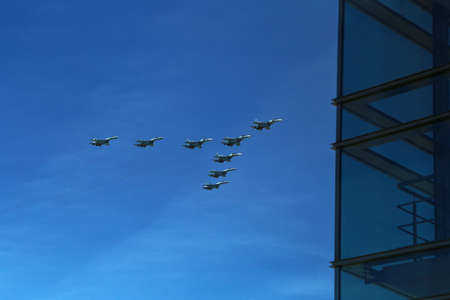 Group of eight russian military fighter jet planes flying in a v shape triangular formation high in blue sky during Vicotry Day parade air show on 9 May in Moscow, Russiaのeditorial素材