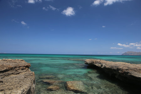 panorama landscape scenic view of isolated deserted rocky beach with blue turquoise sea water and sky with white clouds background on beautiful and colorful Mallorca island in Spainの写真素材
