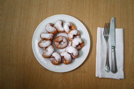 top view of a pile of delicious sweet golden brown doughnuts (donuts) with white powdered icing...