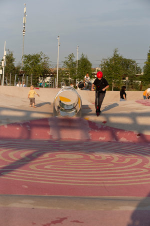 Moscow, Russia - 08.08.2021. a child boy riding a kick scooter in helmet on the children playground with tube at Tyufeleva Roshcha city park, Zilart! melk landscape architecture urban designのeditorial素材