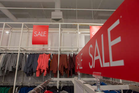 sale discount signs on red rectangular board written in white letters in a clothing storeの写真素材