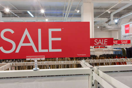 sale discount signs on red rectangular board written in white letters in a clothing storeの写真素材