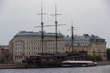 SAINT PETERSBURG, RUSSIA - 08/12/2021 Dutch wooden fluyt merchant sailing ship of XVIII century with three wooden masts on a gray sky and clouds background. 1703 Flying Dutchman restaurantのeditorial素材