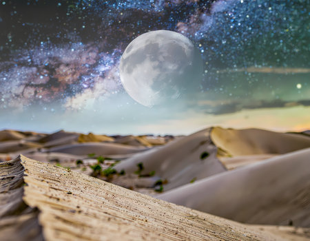 A magical starry night sky with full moon over vast desert landscape. this serene, tranquil view of milky way above sand dunes feels dreamyの素材