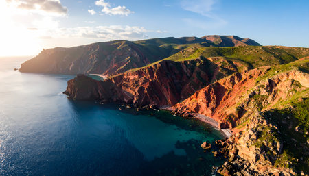 A stunning aerial view of rugged coastline with serene ocean bay and red cliff at sunset. this scenic and tranquil california landscape has majestic mountain and beautiful lightの素材