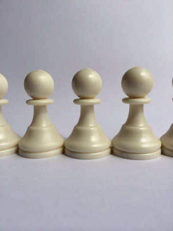 White pawns chess pieces stand in straight lineの素材