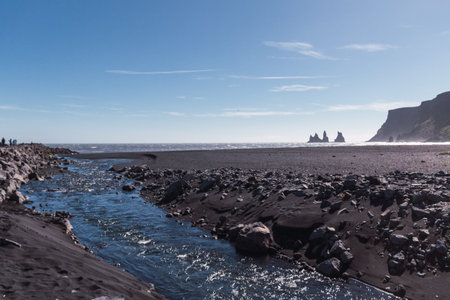 Rock Troll's fingers in the ocean near the beach with black sand in south of Iceland