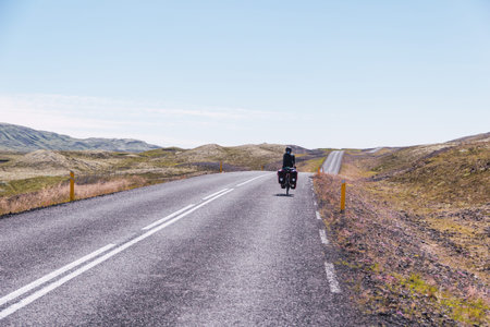 Young girl cycling on a paved road in Iceland.の写真素材