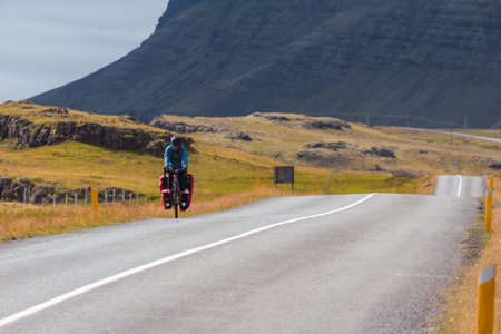 Young girl cycling on a paved road in Iceland.のeditorial素材