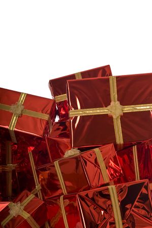 Pile of Christmas presents wrapped in gold foil on red background on white backgroundの写真素材