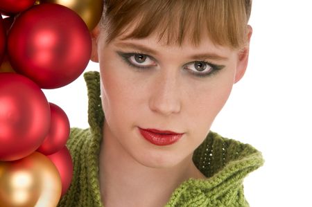 Close-up of young woman with red and gold Christmas balls on white backgroundの写真素材