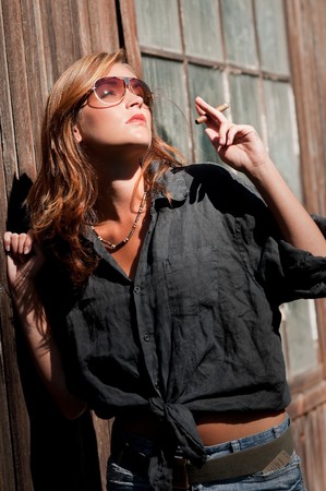Attractive young model with cigar watching sunの写真素材