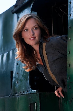 Beautiful woman watching out of green trainの写真素材
