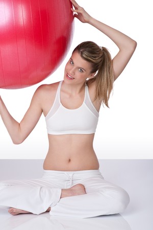 Sportive woman holding big red ball on white backgroundの写真素材