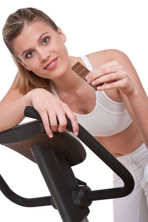 Fitness series - Woman holding piece of chocolate on white backgroundの写真素材