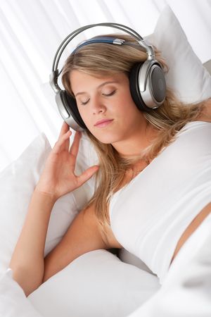 Blond woman with headphones listening to music with closed eyesの写真素材