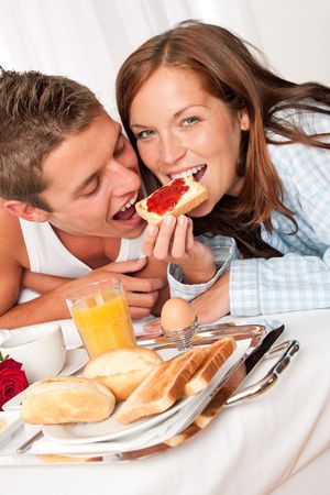 Young happy couple having luxury hotel breakfastの写真素材