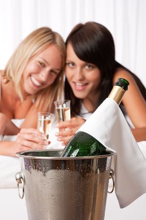 Two young women toasting with champagne  in luxury hotel roomの写真素材