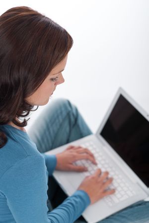 Brown hair woman with laptop on white backgroundの写真素材