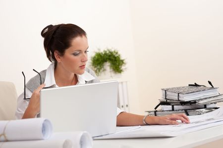 Female architect with laptop sitting at the officeの写真素材