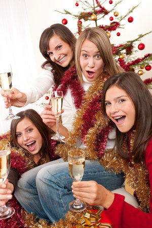 Four young woman having fun on Christmas with champagne