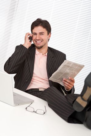 Young businessman on the phone with legs upの写真素材