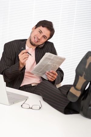 Young businessman on the phone with legs upの写真素材