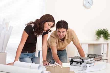 Young man and woman working at architect office with architectural modelの写真素材