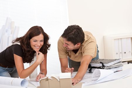 Smiling man and woman working at architect office officeの写真素材