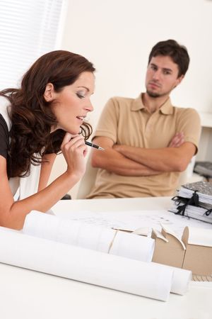 Young woman and man working together at architect officeの写真素材