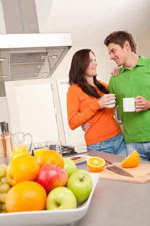 Happy couple drinking coffee in the kitchen togetherの写真素材